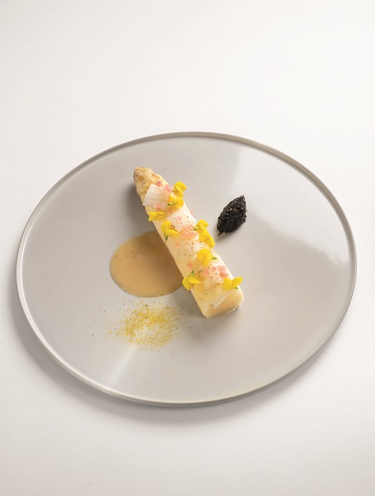 1 I 15 jours avant, infuser à froid les fleurs de genêt dans le vinaigre balsamique blanc.  2 | Faire sécher les fleurs de genêt dans un déshydrateur. Mixer 12 heures avant pour obtenir une poudre fine.  3 | Éplucher les asperges jusqu’à la tête à 14 cm de long, récupérer les parures. Placer les asperges dans un sac sous vide avec une pincée de poivre noir de Sarawak et une pincée de sel marin, ajouter le vinaigre de genêt et souder le sac. Cuire dans un four vapeur ou un cuiseur vapeur à 100°C pendant 13 m
